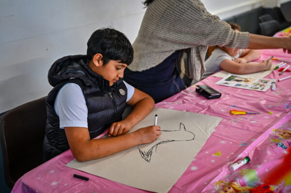 Boy drawing on paper with a pencil in his hand